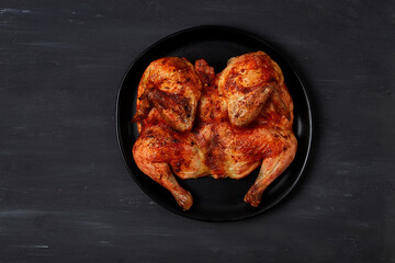 Tobacco chicken, Georgian dish, on a black wooden table, top view, horizontal, no people,