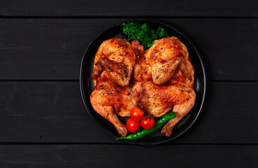 Tobacco chicken, Georgian dish, on a black wooden table, top view, horizontal, no people,