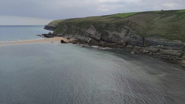 Acantilados de la costa quebrada e isla del Castro unida por un t&oacute;mbolo de arena durante la marea baja, Espa&ntilde;a