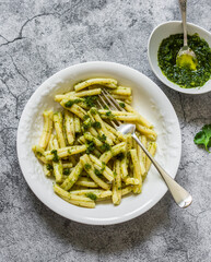 Casarecce pasta with cilantro pesto sauce on a grey background, top view. Delicious vegetarian lunch