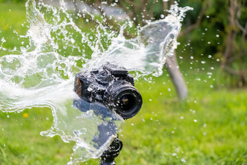 A digital camera on a tripod in the rain