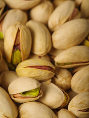 Lots of pistachio nuts. Whole and open nuts with brown and green hearts. healthy and tasty product. Healthy food, pastry shop, shop. Close-up. Macro photography.
