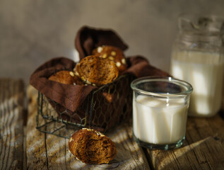Pieces of brown bread in a basket, a jug and a glass of milk. Breakfast, lunch. Beautiful composition. Natural wood texture. Country style. Shop, restaurant, cafe, home cooking.
