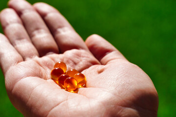Top view on woman's hands holding pile of capsules Omega 3