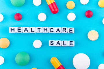 health care is for sale written on cubes with pills and pills around them