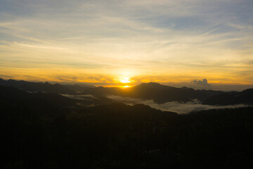 Scenic view of a sunrise over foggy mountain range