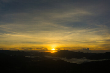 Scenic view of a sunrise over foggy mountain range