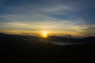 Scenic view of a sunrise over foggy mountain range