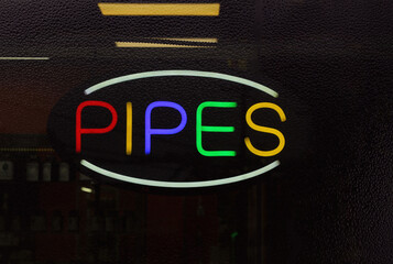 Colorful Neon Pipes Sign in Rainy Window of Smoke Shop