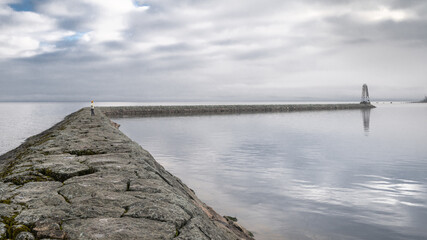 View of the stone pier leading to the lighthouse on the shores of Lake Ladoga. High quality photo