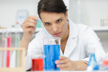 woman lab assistant with flasks with liquids