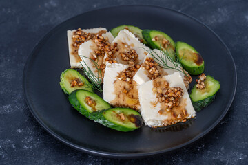Fresh salad with green cucumber and white cheese with olive oil sauce and roasted almonds
