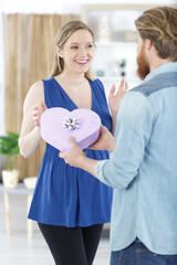 man giving heart shape gift box to a pregnant woman