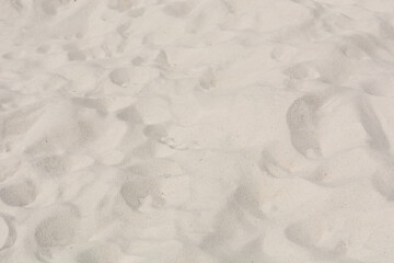 White fine sand with bumps outdoor on a sunny day. Close up and copy space. Background and texture concept