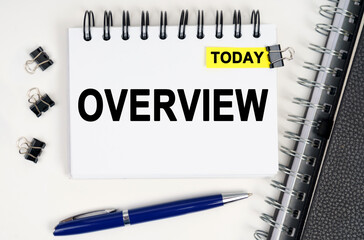 On the table is a pen and a notebook with inscriptions - Today and OVERVIEW