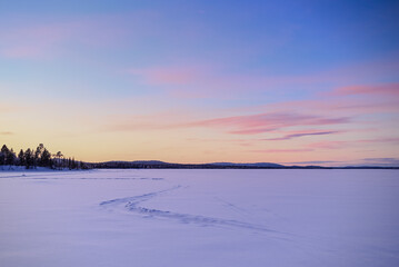 Sunset on a frozen lake in Finnish Lapland