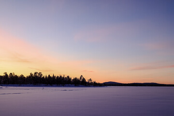 Sunset on a frozen lake in Finnish Lapland