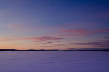 Sunset on a frozen lake in Finnish Lapland