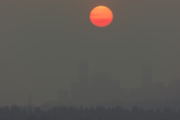 Heavy wildfire smoke surrounds Seattle with orange sun at sunset
