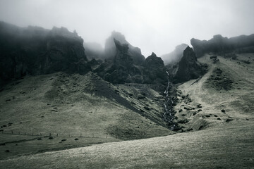 Dramatic foggy cliffs and stream in South Iceland