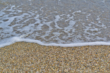 Texture of sand with an edge of sea-wave foam.