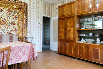 Example of Old Soviet Russian poor interior in Khruschev House. Aged  sideboard, table, chairs,...