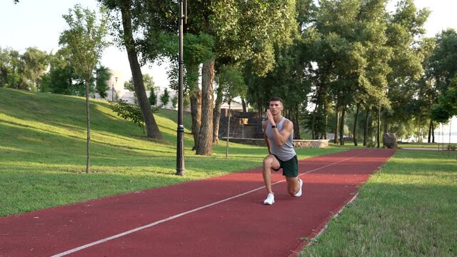 sporty guy trainer warming up with front lunge exercise outdoor, fitness