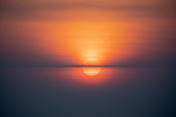 Fototapeta na wymiar An orange sunrise, thin clouds, with a beautiful yellow sun on a cool spring morning.