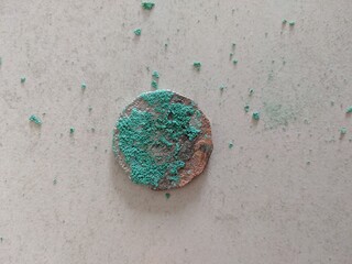 Close up of a 50 cent coin that has corroded and the way the corrosion has shattered as it hit the...