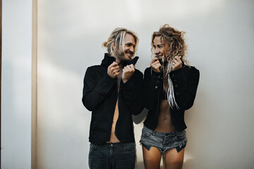 Beautiful athletic couple dressed in black unbuttoned shirts looking into each others eyes