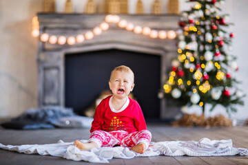 A little boy in Christmas cry pajamas smiles