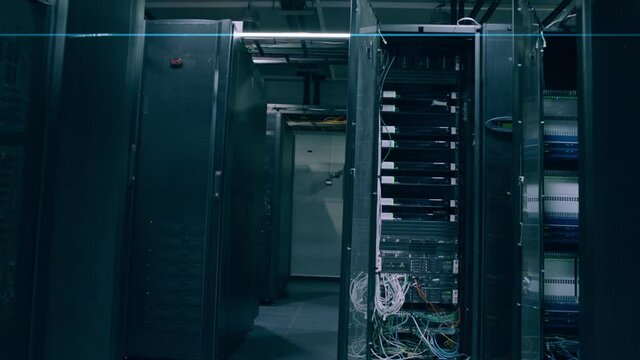 Camera moves through big working data center with server racks .  Real shot of high tech server room with metallic doors . Inside telecom server room. Shot on ARRI ALEXA Cinema Camera with gimbal move