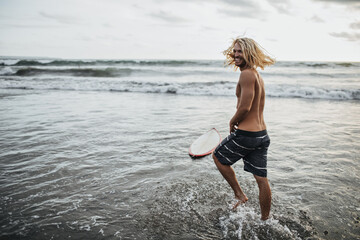 Positive man in shorts laughs and goes to sea