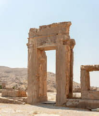 Fabulous view of ruins of the Hadish Palace (the Palace of Xerxes) on blue sky background in Persepolis, Iran. Ancient Persian city. Persepolis is a popular tourist destination of the Middle East.