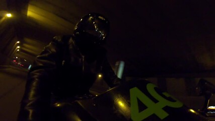 Biker with super sport motorcycle . All in black Motorcyclist riding fast on city road at night . Motorcycle adventure lifestyle . Fast riding of black biker .