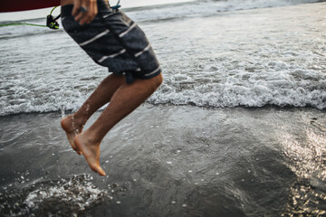 Shot of jumping guy in striped shorts against sea