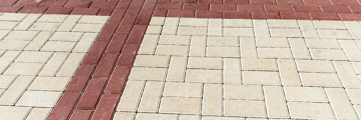 Stone pavement. Texture of stone paved ground. Brown paving slabs on a pedestrian sidewalk or road. Perspective. Wide panoramic texture for background and design.