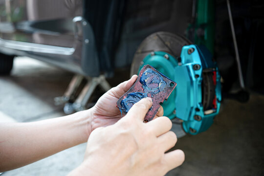 Home Service Car Concept : Close Up Hand A Man Hold Brake Pads And Applying Grease Anti Seize On The Back Brake Pads In Car Caliper Brake And Check System In Basic Maintenance