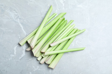 Fresh lemongrass stalks on light grey marble table, flat lay