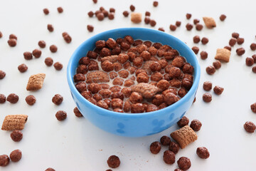 chocolate flakes, breakfast in a blue plate, on a white background
