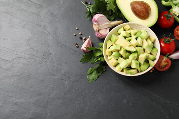 Fresh guacamole ingredients on black table, flat lay. Space for text