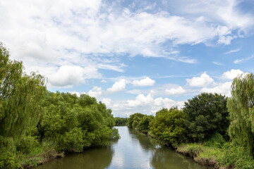 渡良瀬遊水地の近くに流れる谷田川と夏の青空