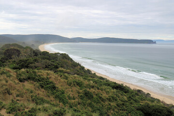 Fototapeta premium View from the lookout at The Neck Bruny Island over the beach with cloudy skies. Tasmania Australia