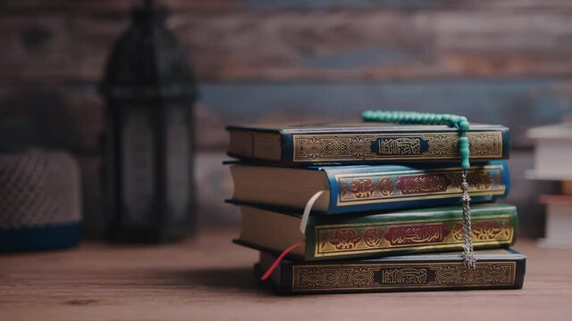 Islamic concept - The Holy Al Quran with written Arabic calligraphy meaning of Al Quran and a beautiful Arabian lamp, Arabic word translation: The Holy Al Quran (holy book of Muslim)