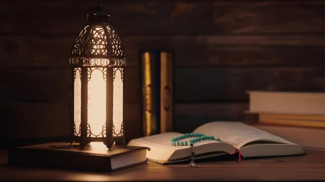 Islamic concept - The Holy Al Quran with written Arabic calligraphy meaning of Al Quran and a beautiful Arabian lamp, Arabic word translation: The Holy Al Quran (holy book of Muslim)