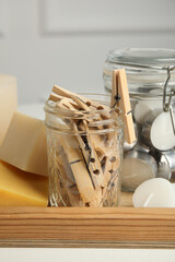 Many clothespins, candles and soap bars on wooden tray, closeup