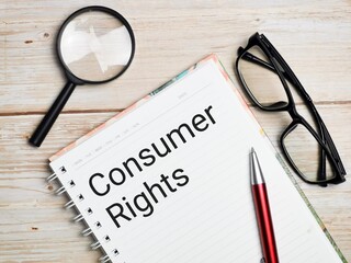 Consumer rights written on note book with pen,magnifying glass and eye glasses.