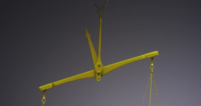 Yellow jewelry retro weigher . The scales are unsteady until they balance . Symbol of justice . Weights on the scales . Studio shot on RED EPIC Cinema Camera with strobe light .
