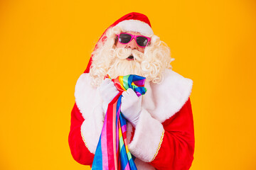 Gay Santa Claus holding the LGBT flag. Christmas Gay Pride concept.Gay Santa Claus on yellow...