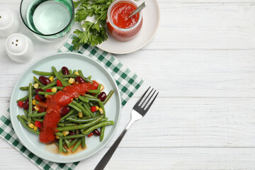 Delicious salad with green beans and tomato sauce served on white wooden table, flat lay. Space for text